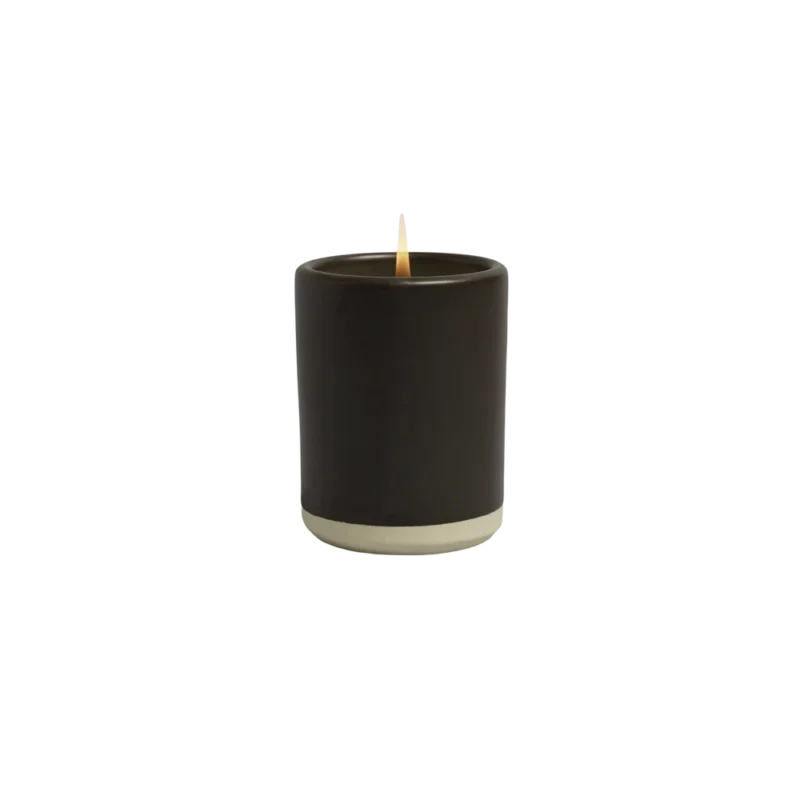 Norden Big Sur Ceramic Candle — hand-thrown stoneware candle with matte black glaze and natural clay base, lit flame