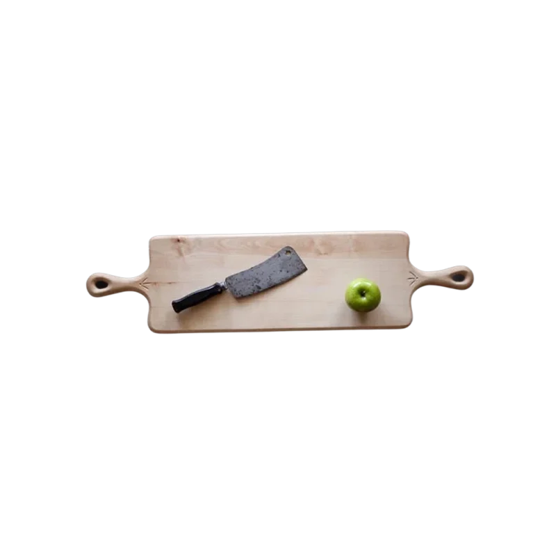 Blackcreek Mercantile Cutting Board — single-piece maple board with carved handles, cleaver and apple shown for scale