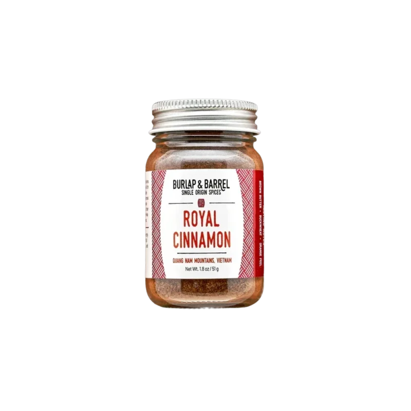 Burlap & Barrel Royal Cinnamon – single-origin ground cinnamon in glass jar, deep rust-red powder with silver lid and red chevron label