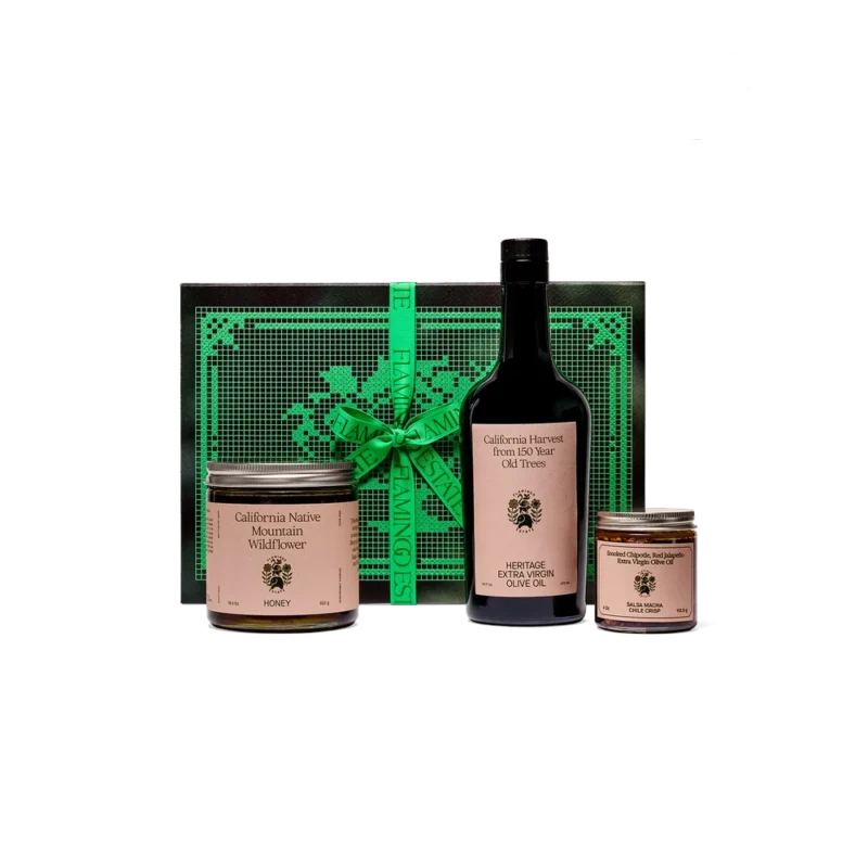Flamingo Estate The Chef's Kiss — gourmet gift set with Heritage EVOO bottle, wildflower honey jar, and salsa macha chile crisp in embossed green gift box with grosgrain ribbon