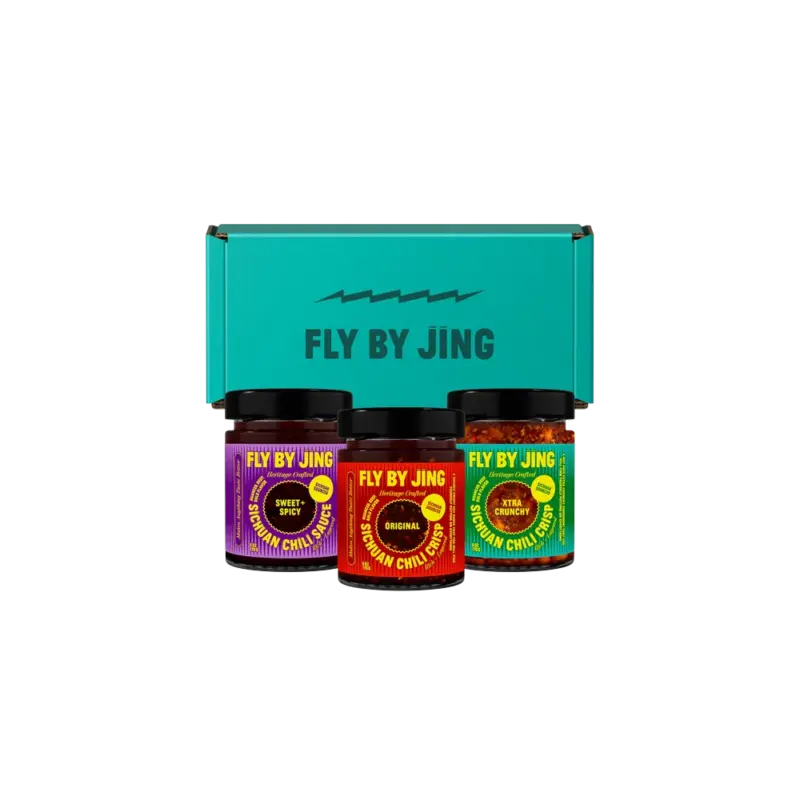 Fly By Jing Sichuan Chili Crisp Trio -- three glass jars of Sichuan sauce in red, purple, and green labels with teal gift box